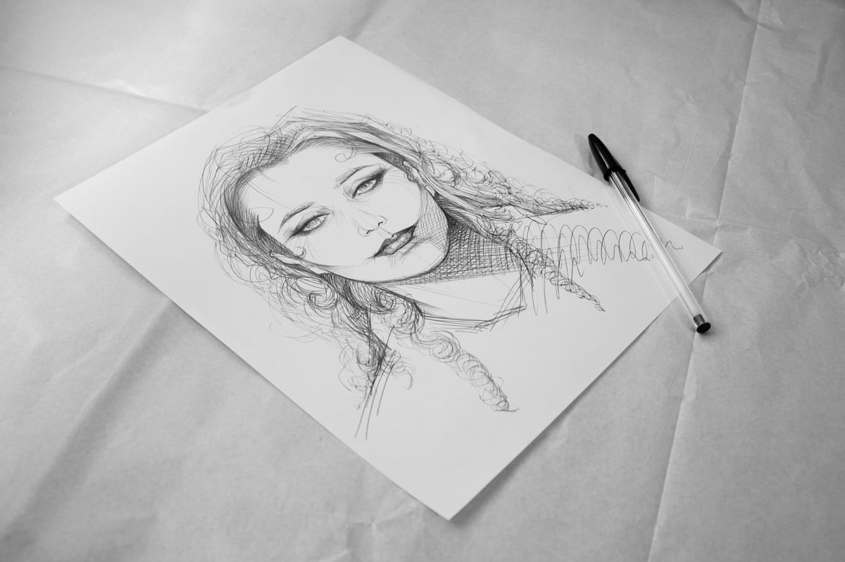 A partially revealed pencil portrait sketch